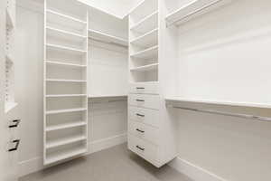 Walk in closet featuring light colored carpet