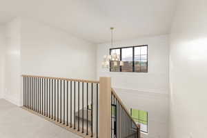 Staircase featuring a chandelier and carpet flooring
