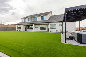 Rear view of house featuring a patio, stucco siding, a pergola, a fenced backyard, and a tile roof