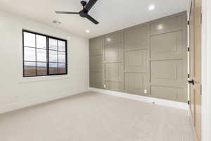 Carpeted spare room featuring ceiling fan and recessed lighting