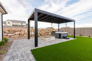 Fenced backyard featuring a patio area, a pergola, and a hot tub