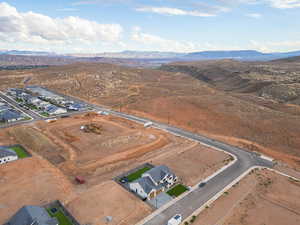 Aerial overview of property's location featuring a mountainous background and nearby suburban area