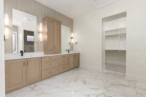 Full bathroom with light marble finish floors, double vanity, and a spacious closet