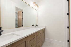 Bathroom with double vanity and light tile patterned floors