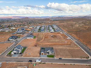 Aerial view of property and surrounding area with a mountain backdrop and nearby suburban area