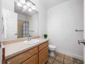 Full bathroom featuring vanity, a shower with shower curtain, and light tile patterned floors
