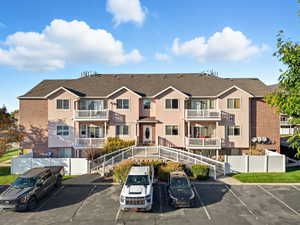 View of building exterior featuring covered and uncovered parking and a residential view