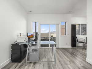 Home office with light wood-type flooring and baseboards