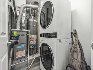 Laundry area with stacked washer / dryer, secured water heater, and heating unit