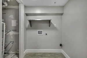 Washroom with hookup for a washing machine, light wood-style flooring, electric dryer hookup, heating unit, and water heater