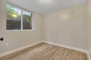 Unfurnished room with baseboards and wood finished floors