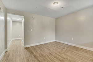Empty room with baseboards and light wood-style flooring