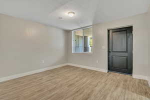 Spare room featuring light wood-style flooring and a textured ceiling