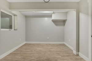 Below grade area featuring light wood-style flooring and baseboards
