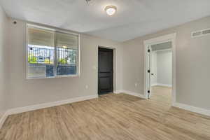Unfurnished bedroom with light wood-style flooring and a textured ceiling