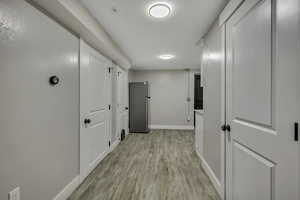 Corridor with baseboards and light wood-style flooring