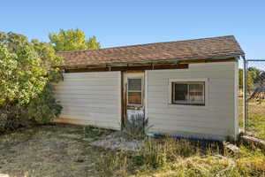 Back of property featuring a shingled roof