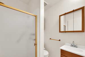 Full bath with vanity, a stall shower, and a textured ceiling