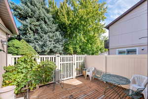 Wooden terrace with a fenced backyard