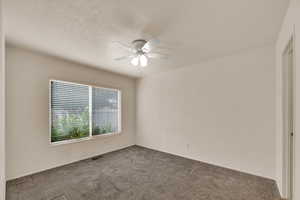 Unfurnished bedroom featuring carpet flooring, a ceiling fan, and a textured ceiling
