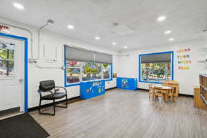 Recreation room with a textured ceiling and recessed lighting