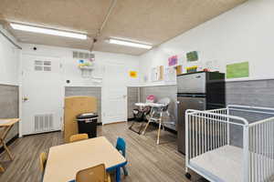 Miscellaneous room featuring wood finished floors, a wainscoted wall, and a textured ceiling