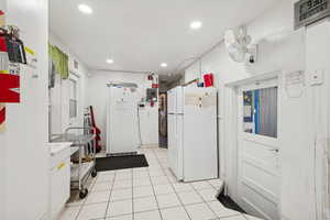 Kitchen with freestanding refrigerator, recessed lighting, light tile patterned floors, white cabinetry, and light countertops