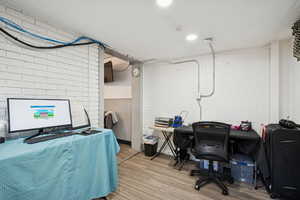 Office space featuring wood finished floors and concrete block wall