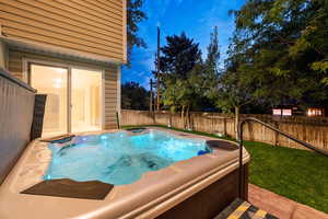 View of pool featuring a hot tub, a fenced backyard, and a patio area