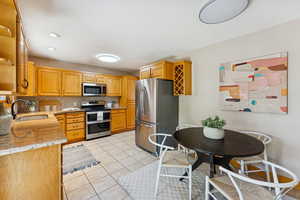 Kitchen featuring stainless steel appliances, backsplash, light tile patterned floors, light stone countertops, and recessed lighting