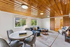 Dining area featuring wood ceiling, carpet floors, and ornamental molding