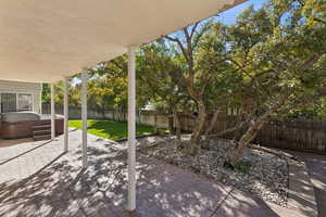 Fenced backyard with a hot tub and a patio
