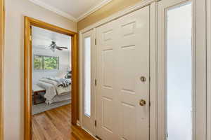 Entryway featuring wood finished floors, crown molding, and a ceiling fan
