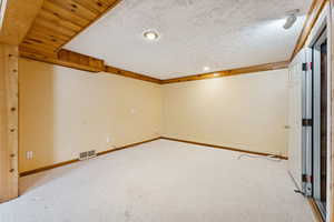 Carpeted spare room featuring a textured ceiling