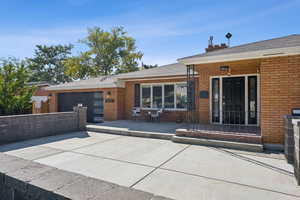 Rear view of house featuring brick siding and roof with shingles