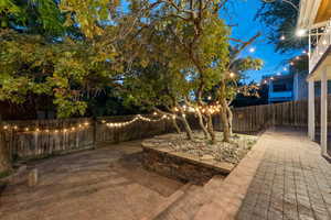 Yard at twilight featuring a patio area and a fenced backyard