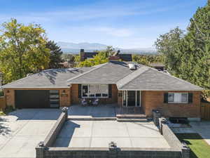 View of front facade featuring a mountain view, brick siding, driveway, and a garage
