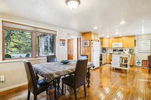 Dining room with light wood finished floors and recessed lighting