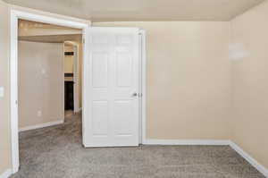 Carpeted spare room with baseboards and a textured ceiling