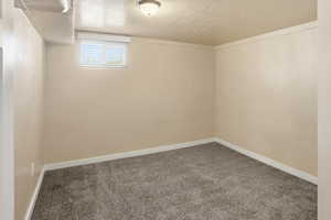 Empty room with a textured ceiling and carpet