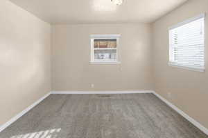 Carpeted empty room with baseboards and a textured ceiling