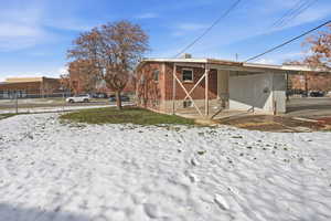 Snow covered property with an attached carport