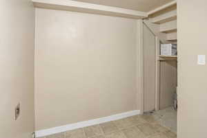 Unfurnished room featuring a textured ceiling and baseboards