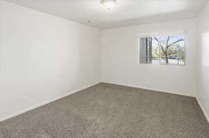 Carpeted empty room featuring baseboards