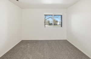 Carpeted spare room with baseboards