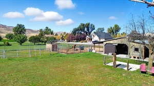View of yard featuring an outbuilding, an exterior structure, and a rural view