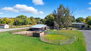 View of yard featuring a view of countryside, an outdoor structure, an exterior structure, a patio area, and driveway