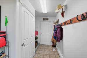 Mudroom featuring a baseboard heating unit and light tile patterned flooring