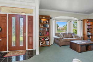 Living room with crown molding and baseboards