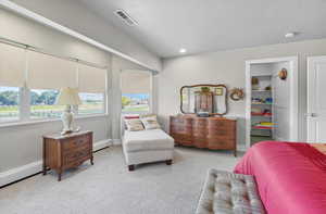Carpeted bedroom with multiple windows, a textured ceiling, baseboard heating, and recessed lighting
